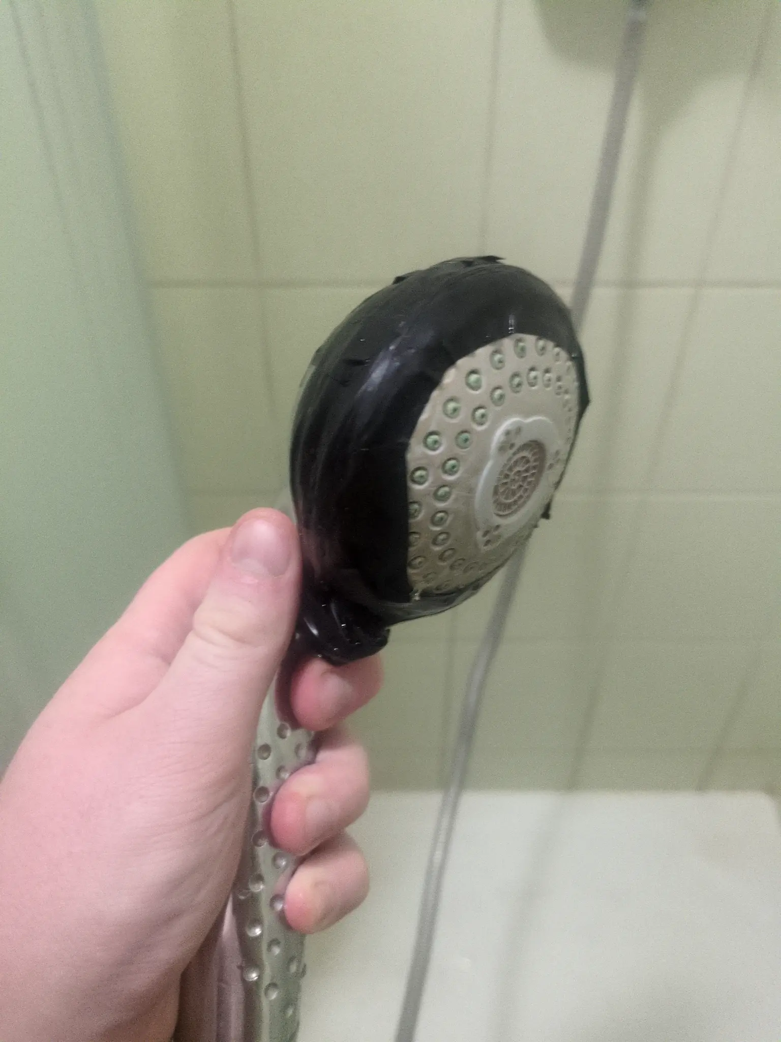 Shower head from side. Lots of electrical tape around.